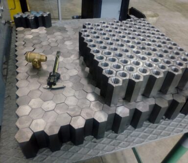 Piattaforma di produzione meccanica con pezzi esagonali lavorati, esemplificando la sinergia tra tecnologie avanzate e controllo numerico (CNC).